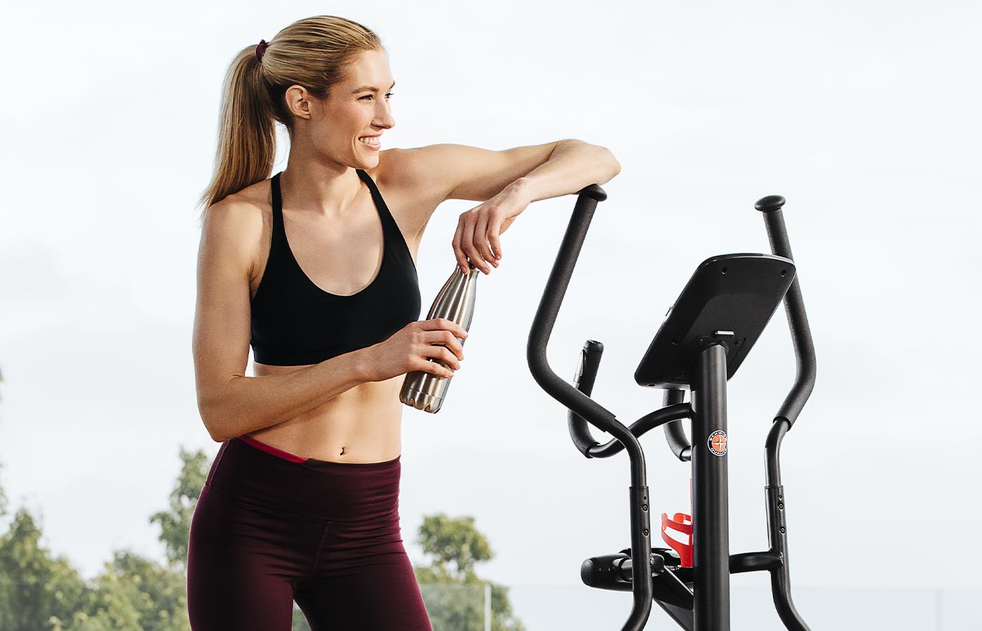 Woman leaning on elliptical after workout